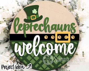 May include: A round wooden sign with a green shamrock hat, a black belt with a gold buckle, and the text "Leprechauns Welcome". The sign has a green and white checkered pattern.