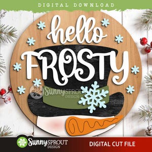 May include: A round wooden sign featuring the text hello FROSTY in white script and block lettering. The design includes a black top hat with a green band, a large light blue snowflake, smaller light blue snowflakes, and an orange carrot nose.