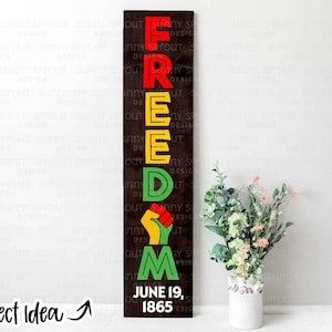 Puede incluir: Un letrero de madera con la palabra "FREEDOM" en letras grandes y coloridas. Las letras son rojas, amarillas, verdes y negras. El letrero también incluye un gráfico de puño en alto y el texto "June 19, 1865".