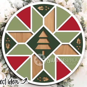 May include: Circular wooden Christmas ornament with a geometric design. The ornament features red, green, and natural wood tones, with a Christmas tree cutout in the center. The text "Project Idea" is visible on the bottom left.