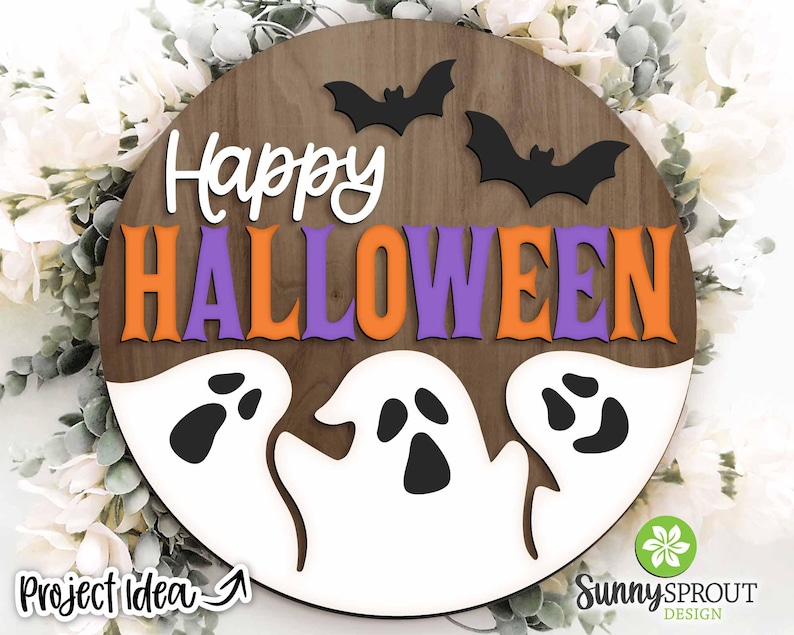 May include: A round wooden sign with the words "Happy Halloween" in orange and purple letters. Three white ghosts with black eyes are on the bottom of the sign.