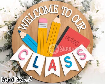 Puede incluir: Un letrero de madera que dice "Bienvenido a nuestra clase". El letrero tiene un lápiz azul, dos lápices amarillos y una libreta roja con la palabra "notas" escrita en ella. El letrero está decorado con banderines blancos que deletrean la palabra "CLASE".