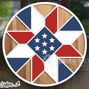 Może przedstawiać: Okrągła drewniana dekoracja ścienna z patriotycznym wzorem. Wzór przedstawia czerwone, białe i niebieskie geometryczne kształty ułożone w gwiazdę, z centralnym niebieskim kwadratem z białymi gwiazdami. Widoczny jest tekst "Project Idea".