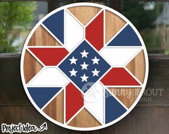 May include: A round wooden wall hanging with a patriotic design. The design features red, white, and blue geometric shapes arranged in a star pattern, with a central blue square containing white stars. The text "Project Idea" is visible.