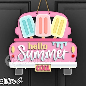 May include: A pink wooden door hanger shaped like a truck bed, with three popsicle-shaped cutouts in blue, pink, and yellow. The words "hello Summer" are written in white script, with "COOL" on the license plate.
