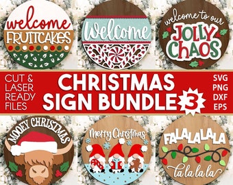 May include: A set of six Christmas signs featuring various festive designs. The signs include "Welcome to our Jolly Chaos", "Welcome Fruitcakes", "Welcome", "Mooey Christmas", "Merry Christmas" with two gnomes, and "Falalalala la la la la".
