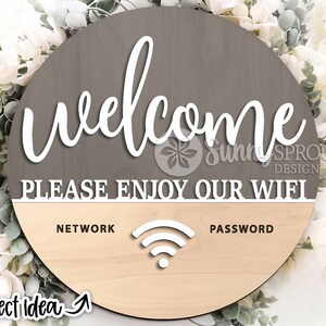May include: A round wooden sign with a gray top half and a light wood bottom half. The top half says "Welcome" in white cursive lettering and "Please Enjoy Our Wifi" in white block lettering. The bottom half has the words "Network" and "Password" in white block lettering, with a wifi symbol in between.