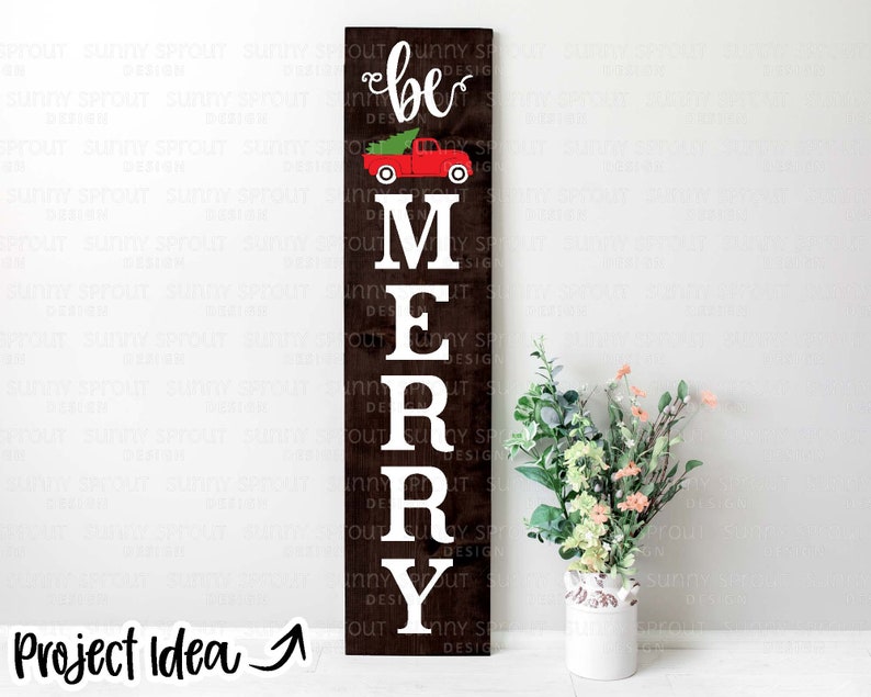 May include: A wooden sign with the words "be merry" in white letters. A red truck with a Christmas tree in the back is above the word "be".