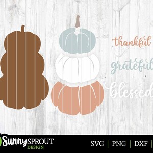 K&ouml;nnte beinhalten: Ein digitales Design mit drei &uuml;bereinander gestapelten K&uuml;rbissen in den Farben Braun, Wei&szlig; und Pfirsich. Der Text "thankful", "grateful" und "blessed" ist in einer kursivschriftlichen Schriftart geschrieben.