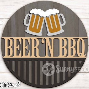 May include: A round wooden sign with a gray wood grain background. The sign features two beer mugs with white foam and the text "BEER 'N BBQ" in a decorative font. The bottom section has a grill design.