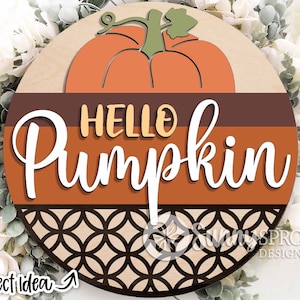 May include: A round wooden sign with a brown, orange, and black patterned design. The sign features a large orange pumpkin with a green stem and the text "Hello Pumpkin" in white cursive lettering.