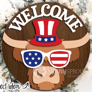 May include: A wooden round sign with the word "WELCOME" in white letters. A brown and white Highland cow with red, white, and blue sunglasses and a red, white, and blue top hat is in the center of the sign.