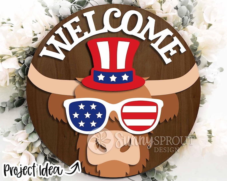 May include: A wooden round sign with the word "WELCOME" in white letters. A brown and white Highland cow with red, white, and blue sunglasses and a red, white, and blue top hat is in the center of the sign.
