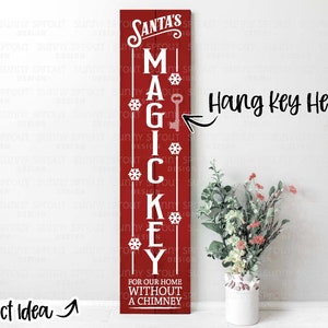 May include: A red wooden sign with white lettering that reads "Santa's Magic Key For Our Home Without A Chimney". There is a keyhole at the top of the sign with the text "Hang Key Here" written above it.