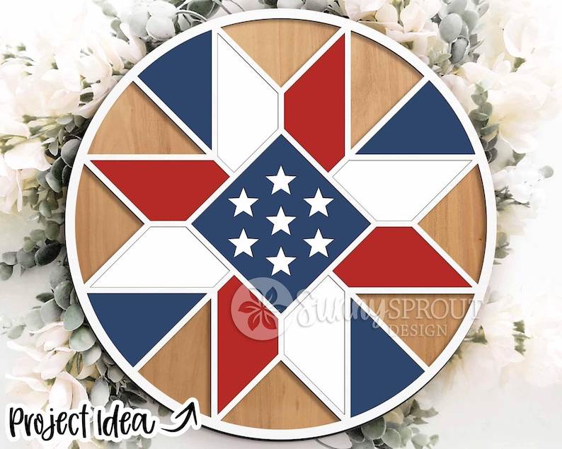 May include: A round wooden wall decor piece with a patriotic design. It features a star pattern in the center with red, white, and blue geometric shapes. The text "Project Idea" is visible in the lower left corner.
