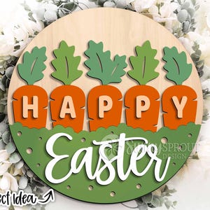 Pu&ograve; includere: Un cartello rotondo di legno con sfondo verde e pois bianchi. Il cartello ha le parole "Buona Pasqua" scritte in bianco con cinque sagome di carote verdi con cime di carote arancioni e la parola "Buona" scritta in arancione sulle carote.