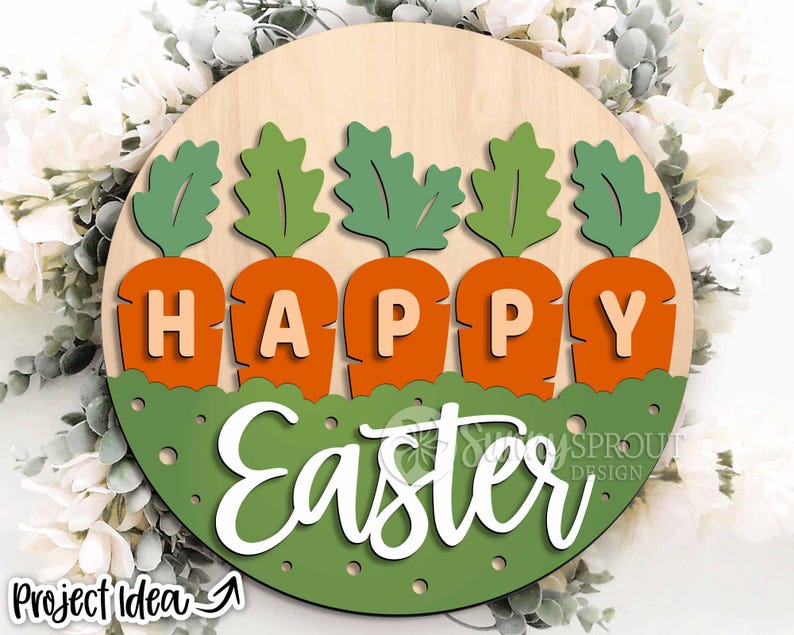 Pu&ograve; includere: Un cartello rotondo di legno con sfondo verde e pois bianchi. Il cartello ha le parole "Buona Pasqua" scritte in bianco con cinque sagome di carote verdi con cime di carote arancioni e la parola "Buona" scritta in arancione sulle carote.