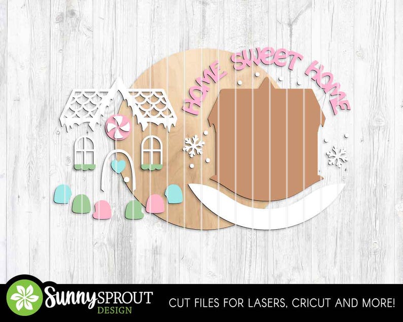 K&ouml;nnte beinhalten: Ein Holzschild mit einem Lebkuchenhaus-Design. Das Schild zeigt die Worte "Home Sweet Home" in Rosa sowie dekorative Elemente wie Schneeflocken, Fenster und S&uuml;&szlig;igkeiten. Entworfen f&uuml;r Laserschneiden und Cricut-Maschinen.