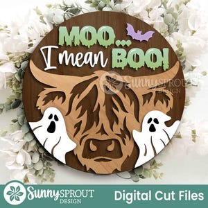May include: A round wooden sign with a Highland cow design and the text "Moo... I mean BOO!" in white and green. Two white ghost figures and a purple bat are also featured. The sign is a digital cut file.