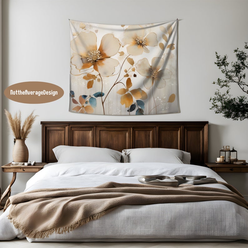May include: A tapestry featuring a watercolor-style floral design with beige, brown, and blue flowers on a white background. The tapestry is hanging on a white wall above a wooden bed frame.