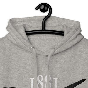 May include: A light gray hoodie with a drawstring hood and a black hanger. The hoodie features the number "1881" in white block letters. The garment is made of a soft, comfortable material.