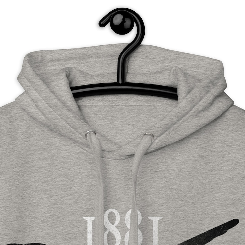 May include: A light gray hoodie with a drawstring hood and a black hanger. The hoodie features the number "1881" in white block letters. The garment is made of a soft, comfortable material.