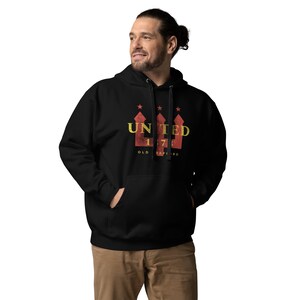 May include: Black hooded sweatshirt with the word "UNITED" in yellow and red, along with the number "175" and the words "OLD STAFFORD". The sweatshirt has a front pocket and a drawstring hood.