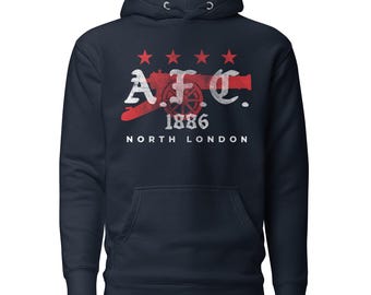 Può includere: Una felpa con cappuccio blu navy caratterizzata da una stampa grafica con il testo AFC, 1886 e NORTH LONDON. Il design include la sagoma di un cannone rosso, quattro stelle rosse e una texture bianca dall'aspetto vissuto sulle scritte.