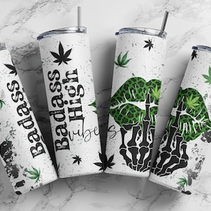 May include: Four white stainless steel tumblers with black straws. The tumblers feature cannabis leaf designs and the phrases "Badass High Vibes" and a skeleton hand giving the middle finger. The tumblers have a distressed, speckled design.