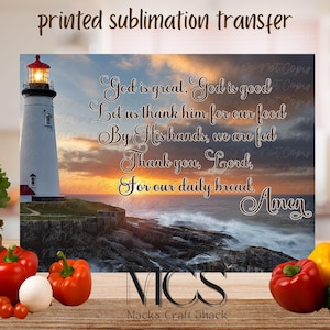 May include: A printed sublimation transfer featuring a lighthouse on a rocky coast at sunset. The text reads "God is great, God is good...Amen." The image includes a variety of fresh vegetables, including red and yellow bell peppers.