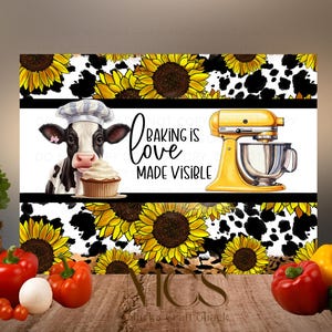 May include: A decorative kitchen sign featuring a cow wearing a chef's hat holding a cupcake, a yellow stand mixer, sunflowers, and the text "Baking is Love Made Visible." The background has a cow print.