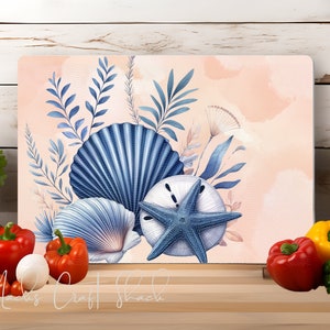 May include: A decorative cutting board with a watercolor design of blue seashells and starfish on a peach background. The design includes blue and white seashells and a blue starfish with a white center.