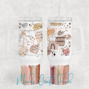May include: White tumbler with a handle and a straw. The tumbler has a colorful design with abstract shapes, flowers, and inspirational quotes. The quotes include "Fear is a lie", "The Lord will fight", "Faith can move mountains", and "He moves the mountains into the sea".