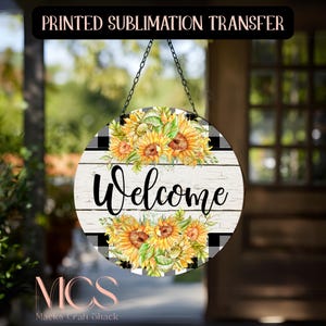 May include: Round wooden sign with a sunflower design and the word "Welcome" in black script. The sign has a white, weathered wood background and black and white buffalo check accents. The sign is hanging from a chain.