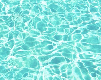 May include: A close-up of a turquoise blue swimming pool with rippling water reflecting the sunlight.