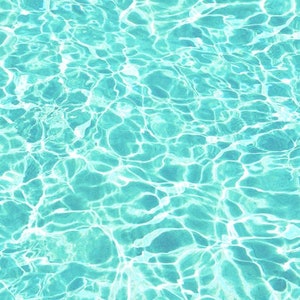 May include: A close-up of a turquoise blue swimming pool with rippling water reflecting the sunlight.
