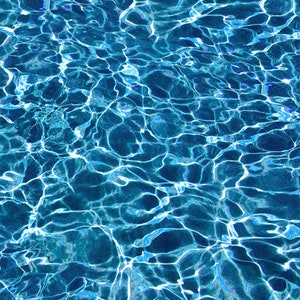May include: A close-up of rippling blue water with white highlights. The water is clear and reflects the sunlight.
