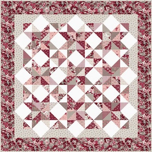 Peut inclure: Une courtepointe avec un fond blanc et un motif de triangles roses, bruns et blancs. La courtepointe est entourée d'une bordure en tissu floral rose et blanc.