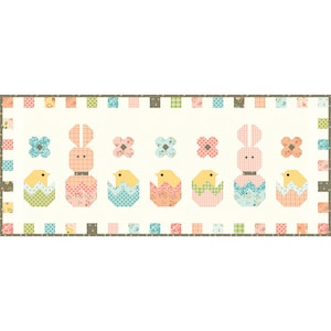 Peut inclure: Un bloc de courtepointe patchwork avec un schéma de couleurs pastel mettant en scène un lapin et des poussins dans des œufs. Le bloc est entouré d'une bordure de petits carrés patchwork.