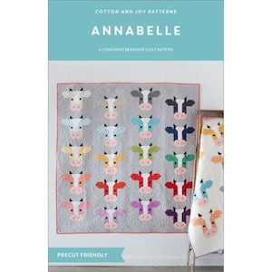 May include: A quilt pattern called "Annabelle" featuring a colourful patchwork design of cow faces. The pattern is described as a "confident beginner quilt pattern" and is "precut friendly".
