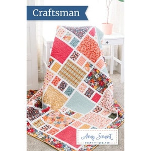 May include: A quilt pattern called "Craftsman" by Amy Smart, Diary of a Quilter. The quilt is made of colourful fabric squares in shades of red, pink, yellow, blue, and green. The quilt is folded and displayed on a white chair.