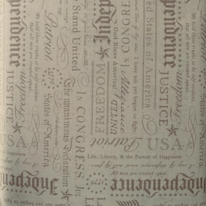 May include: Tan fabric with patriotic text and imagery. Features words like "Independence," "Justice," and "Freedom," along with the American flag and stars. The design is a repeating pattern of text and symbols.
