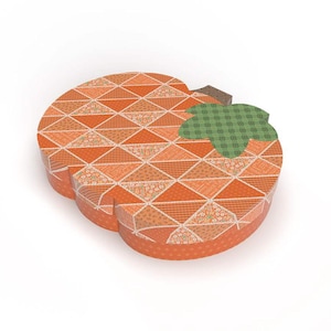 May include: A pumpkin-shaped box with a patchwork design in shades of orange, peach, and cream. The box has a brown stem and green leaf accents, perfect for fall or autumn-themed gifts or decor.
