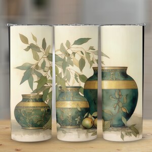 Può includere: Tre vasi in ceramica verde e oro con un motivo di ramo frondoso su sfondo crema. I vasi sono decorati con bordi dorati e motivi intricati.