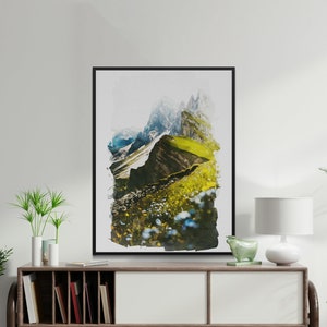 Puede incluir: Una pintura de acuarela enmarcada de una cordillera con hierba verde y flores silvestres. Las montañas están en el fondo y las flores silvestres en primer plano. La pintura está en un marco negro.
