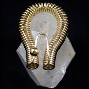 May include: A gold wire wrapped hoop earring with a small ball at the end of the hook.