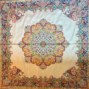 May include: A white fabric tablecloth with a large, intricate paisley design in shades of red, yellow, blue, and green. The design features a central medallion surrounded by repeating patterns.