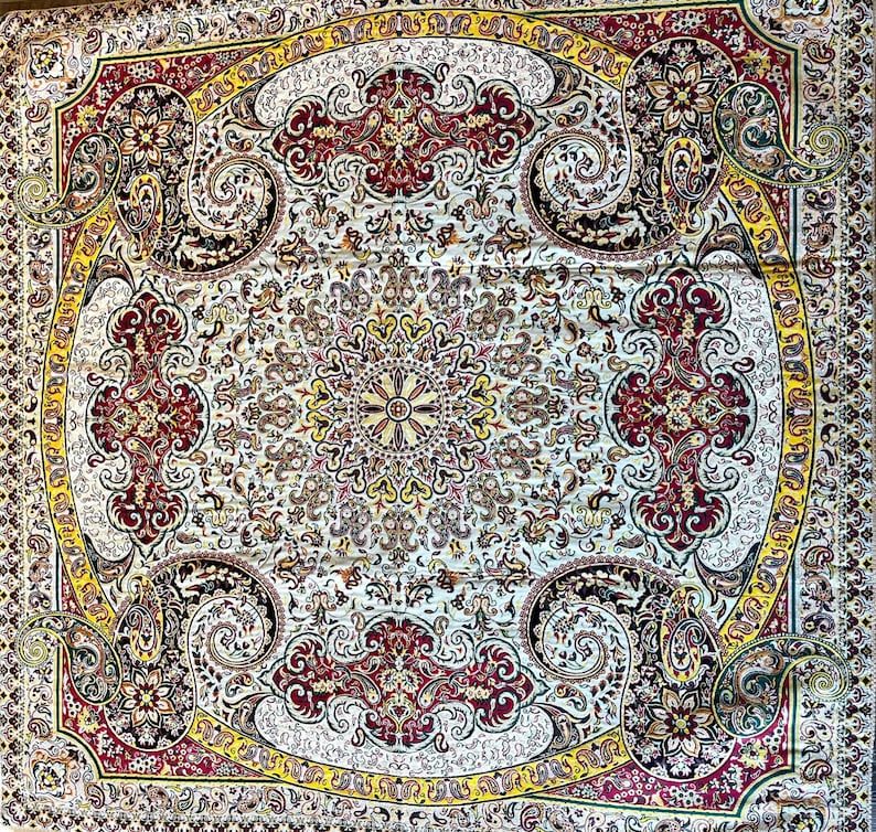 May include: A white rug with a detailed floral pattern in shades of red, yellow, and green. The rug has a central medallion with a repeating pattern of flowers and leaves.
