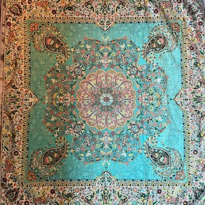 May include: A turquoise blue rug with a floral pattern. The rug has a white border with a floral design. The center of the rug has a large, intricate floral design.