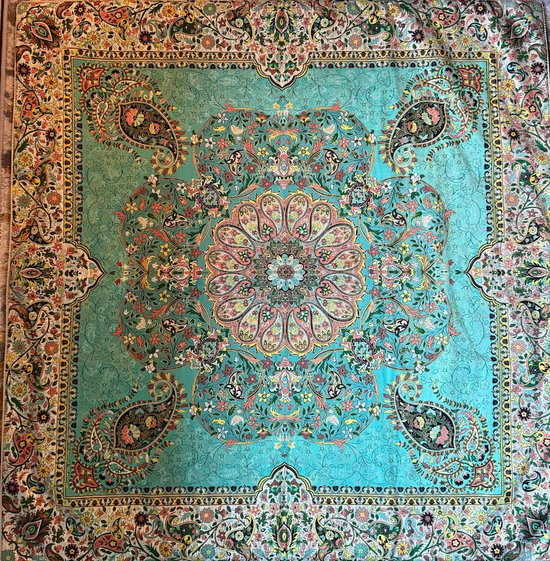 May include: A turquoise blue rug with a floral pattern. The rug has a white border with a floral design. The center of the rug has a large, intricate floral design.